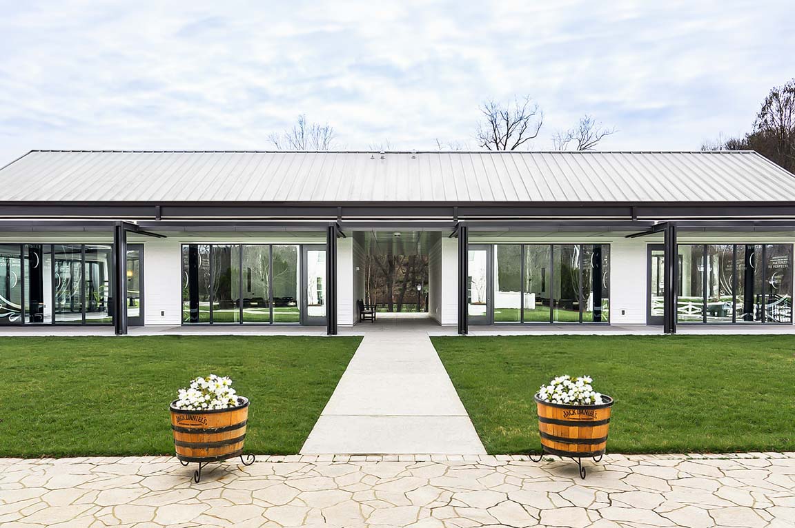 Modern whiskey distillery exterior with glass walls.