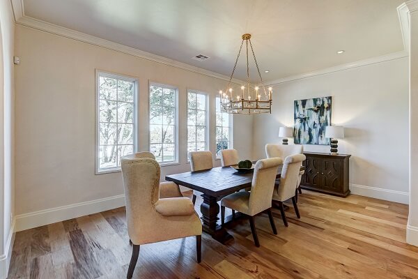 Traditional style dining room with wood floors and a row of white casement windows