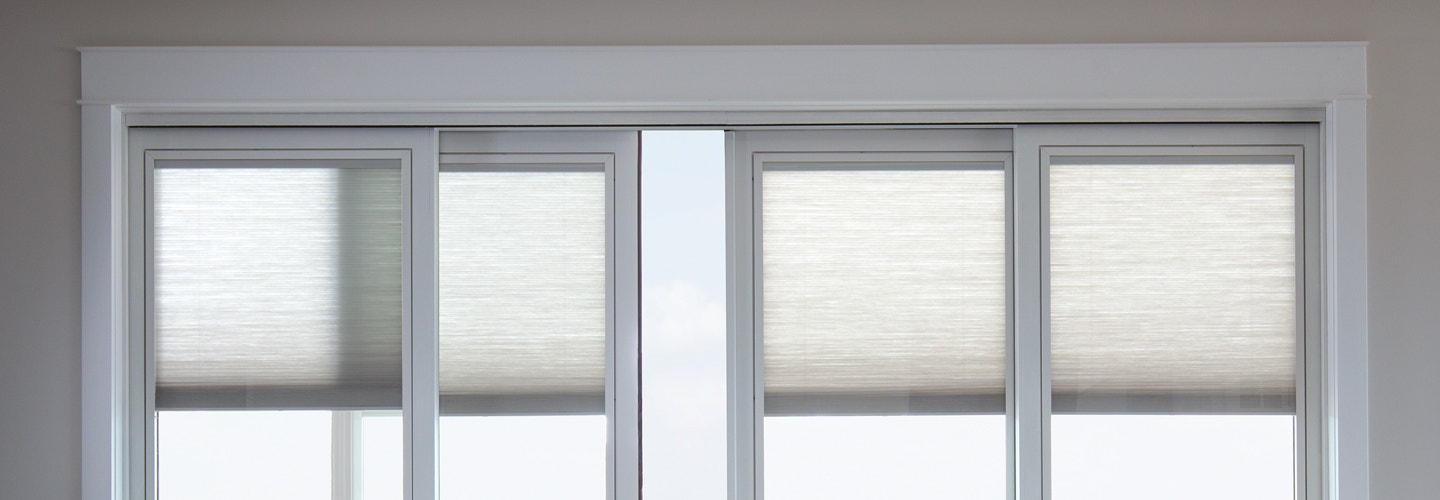 top part of a four panel sliding door with blinds between the glass