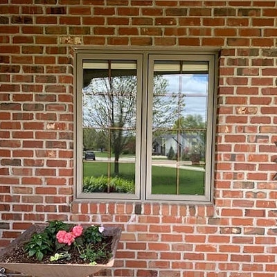 An almond-colored sliding window has been replaced by two Pella Impervia fiberglass casement windows.