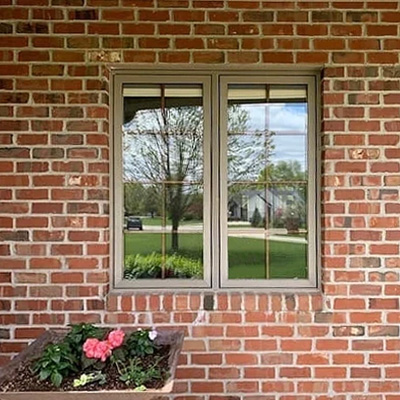 An almond-colored sliding window has been replaced by two Pella Impervia fiberglass casement windows.