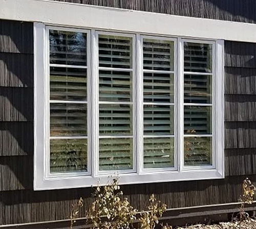 outdated casement windows on a wood-sided Kansas home
