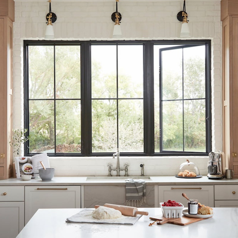 Impervia Casement window black framed over kitchen sink w/ easy slide operator