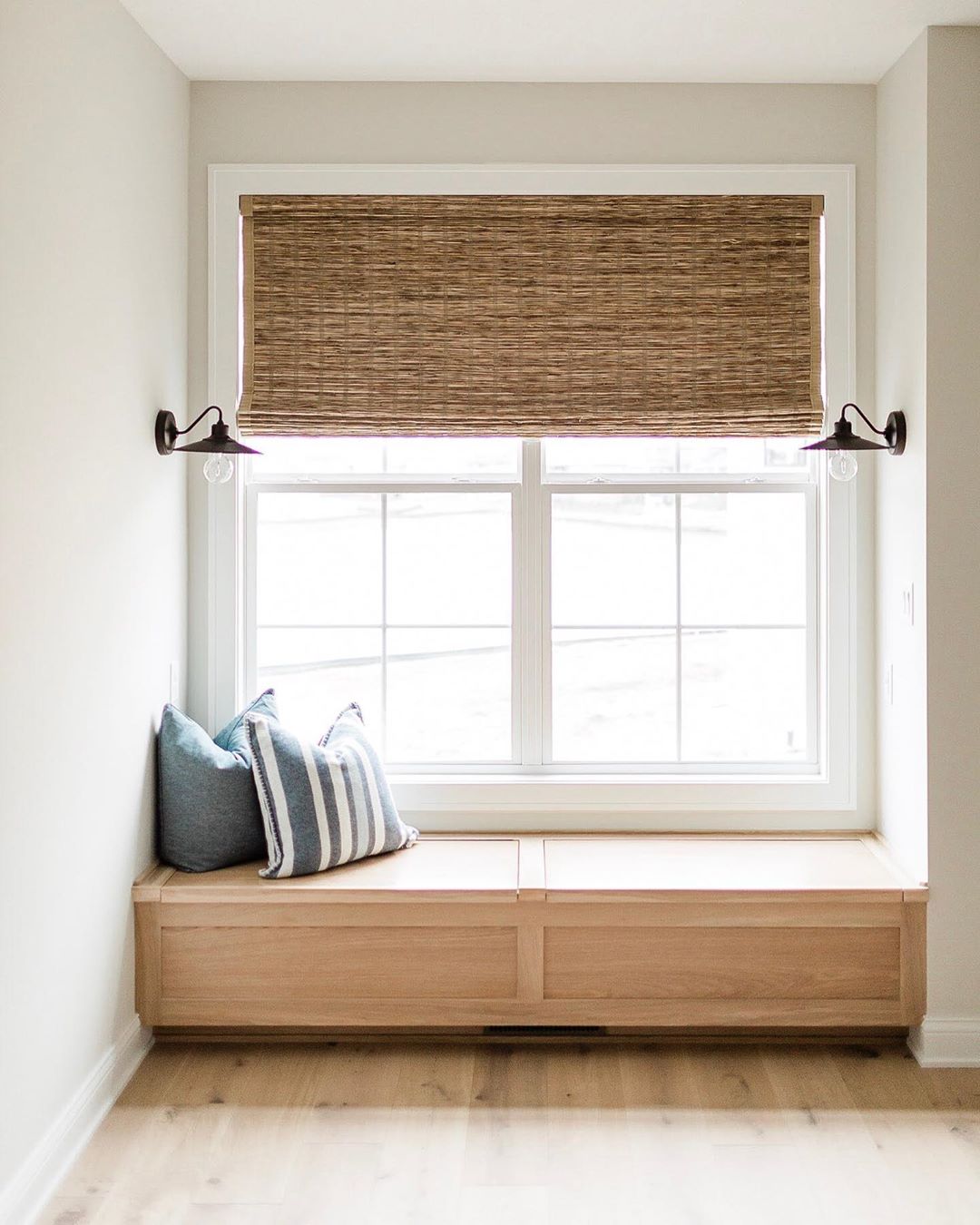 window seat with wood bench, white window, and shade