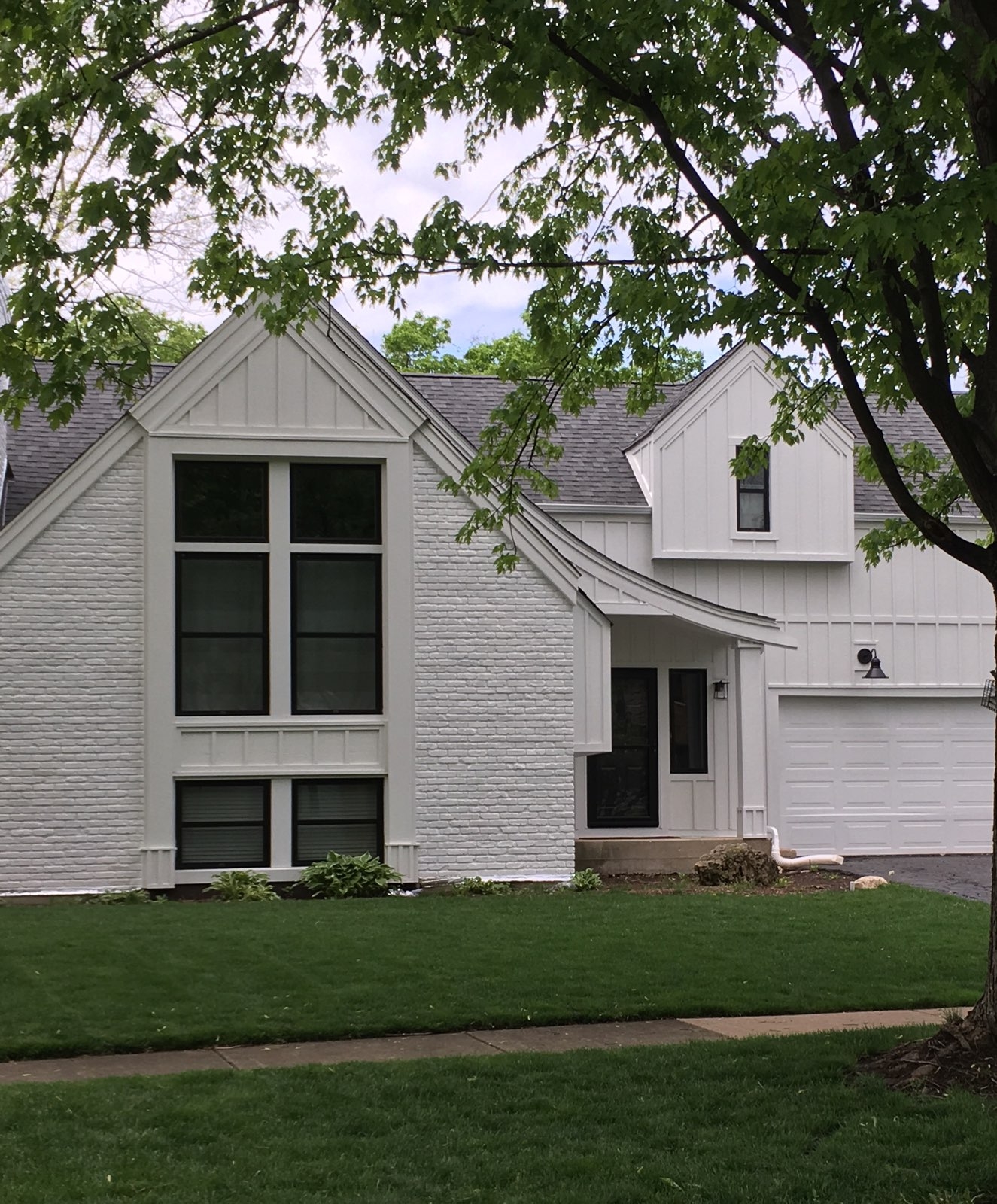 Black Windows Transform Farmhouse Style Home Renovation two story home with painted white brick has large black double-hung windows