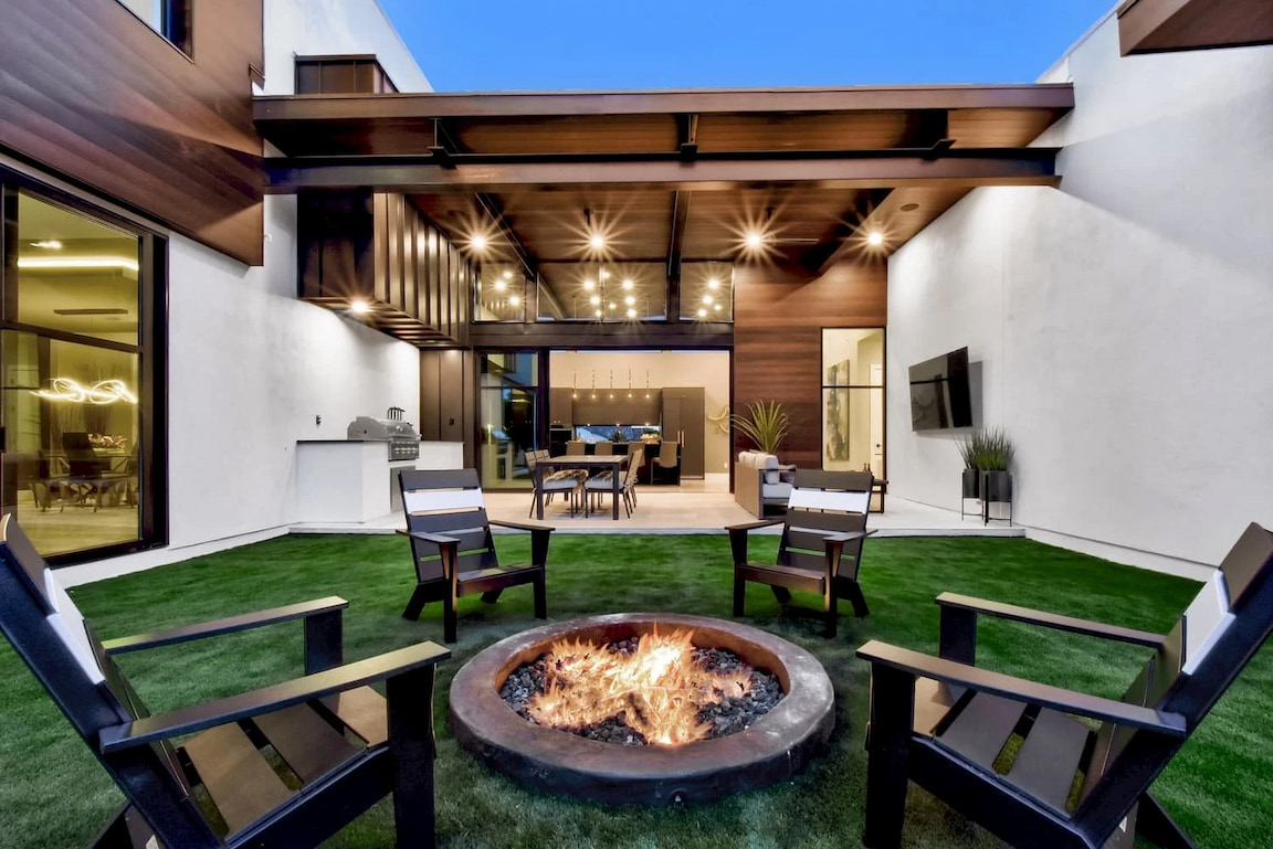 Backyard of modern San Antonio home with a fire pit with newly installed windows and patio doors.