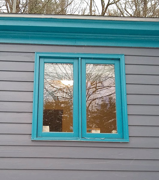 Before image of teal window frame in need of replacement on  Great Barrington home.
