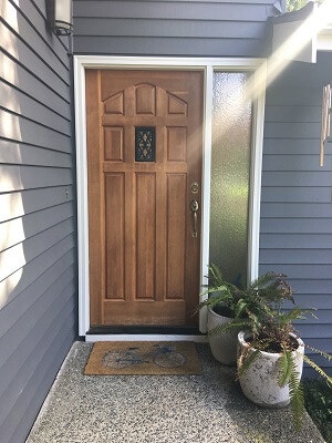 Old wood mid-century style front door on blue house