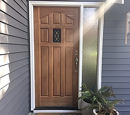 Old wood mid-century style front door on blue house