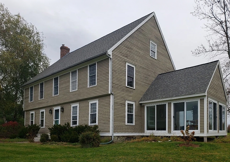 Exterior view of Vermont historical home with outdated windows.