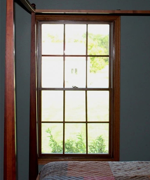 a single wood double-hung window on a gray wall