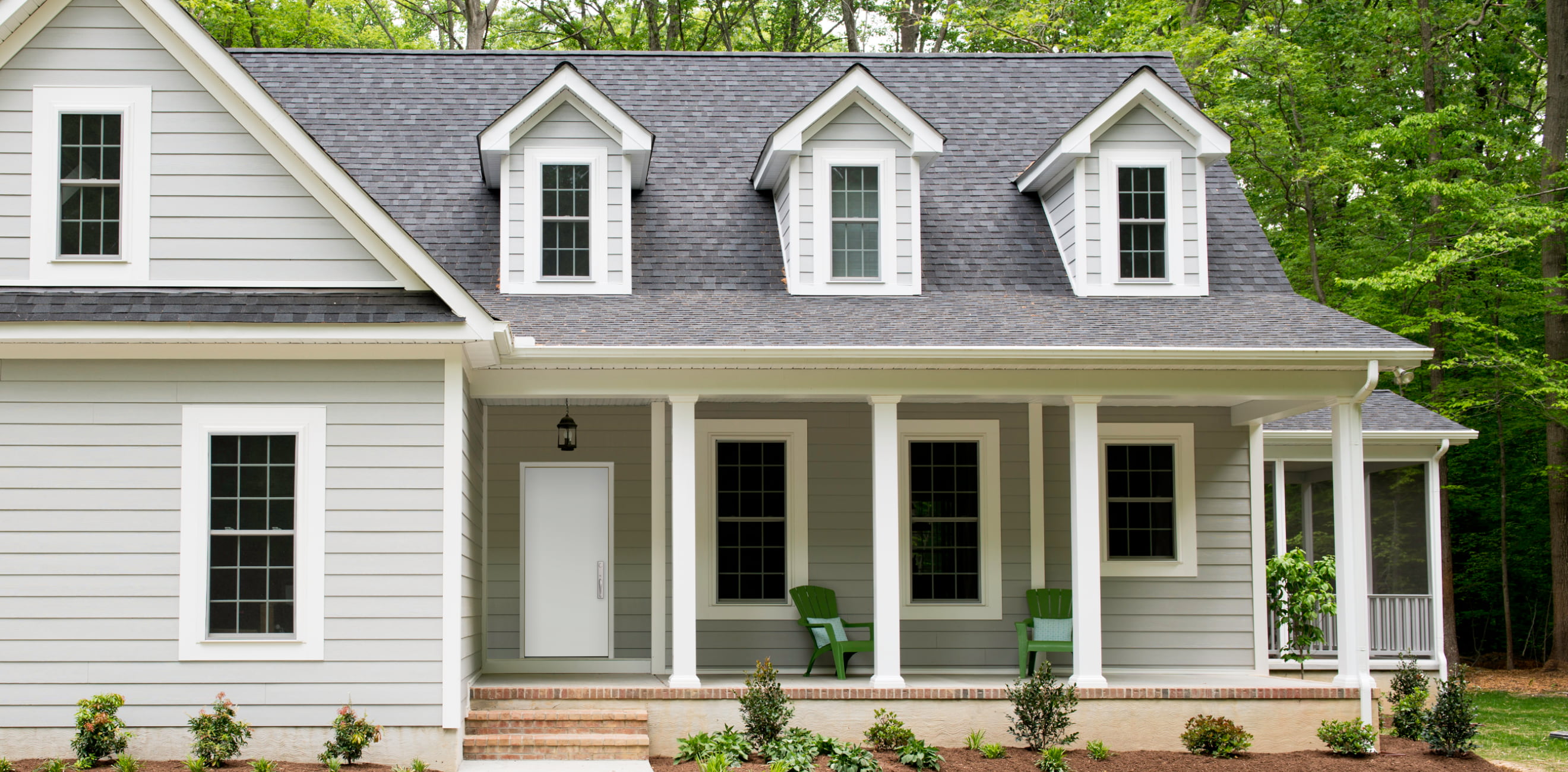 gray single-story home with a deck outside the entry door in white