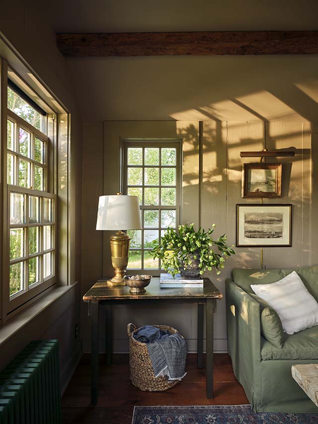Cozy room with Cape Cod–style windows, warm wood accents, and soft daylight.
