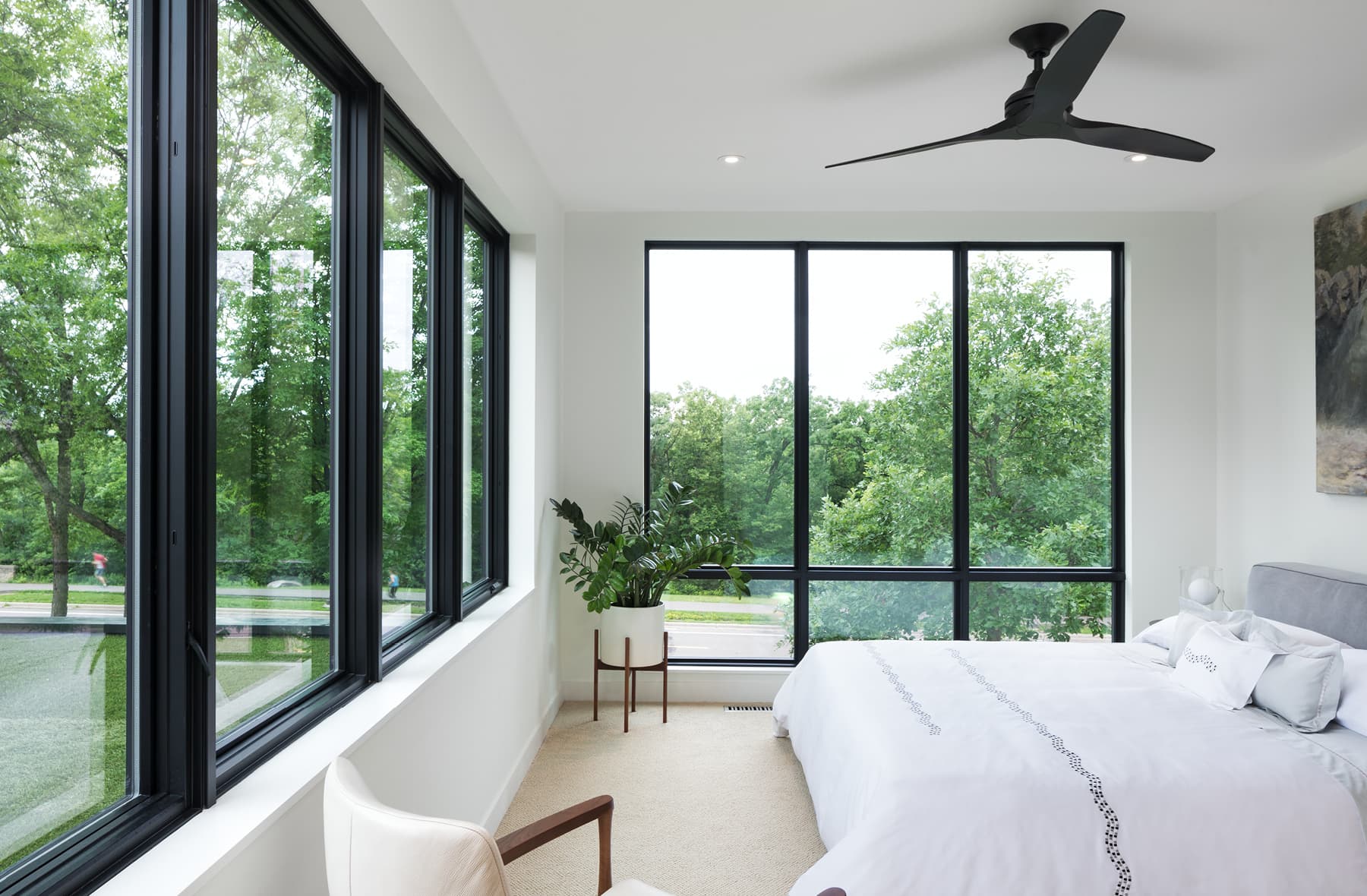 large white master bedroom with wood-clad windows on two walls