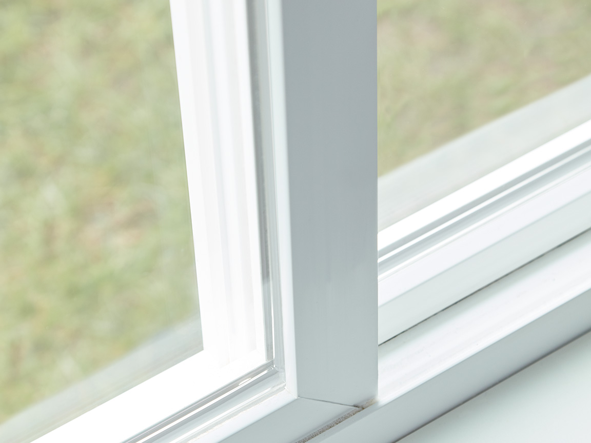 Close-up of a white vinyl window corner showing clean seals and frame construction.