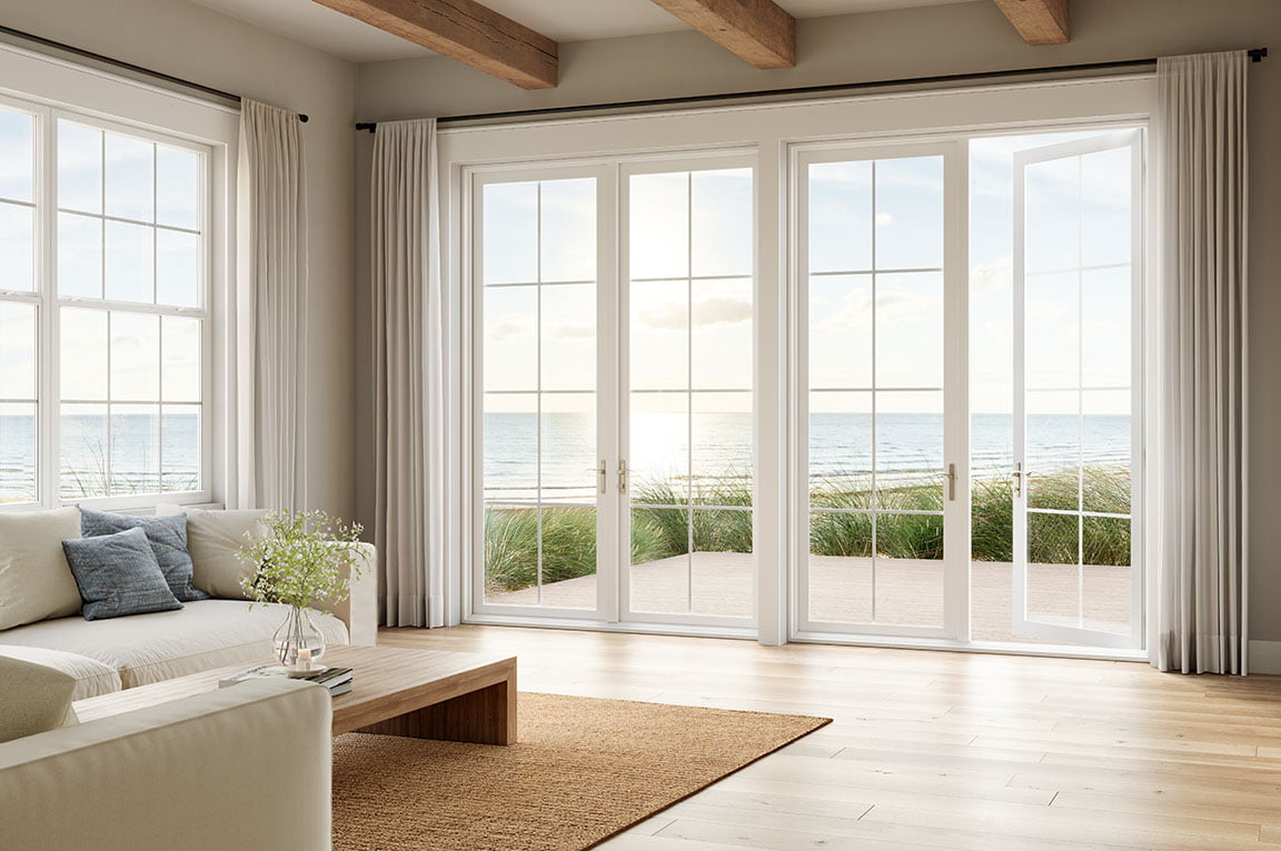 Living room with white French patio doors overlooking the ocean.