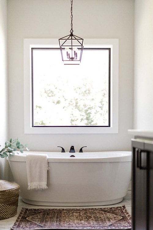 large square picture window over a classic soaker tub