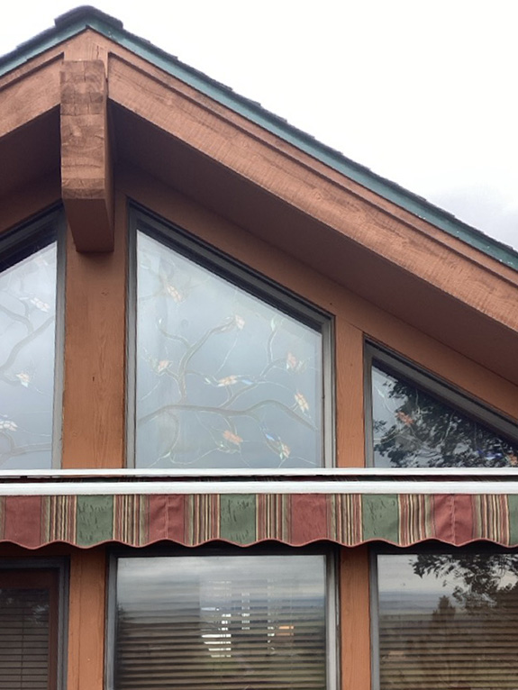 Gable window with a striped awning. 