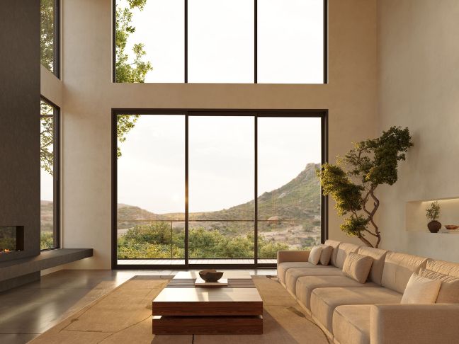 Three floor-to-ceiling picture windows sit below a second set of tall picture windows, framing the living room with the outside nature.