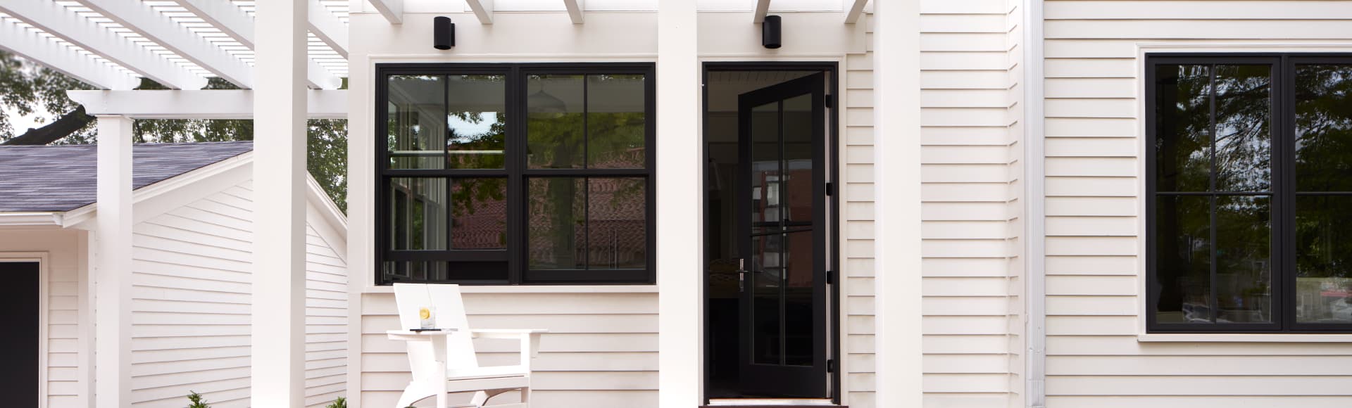 white home with black-trimmed windows and a black-trimmed hinged door
