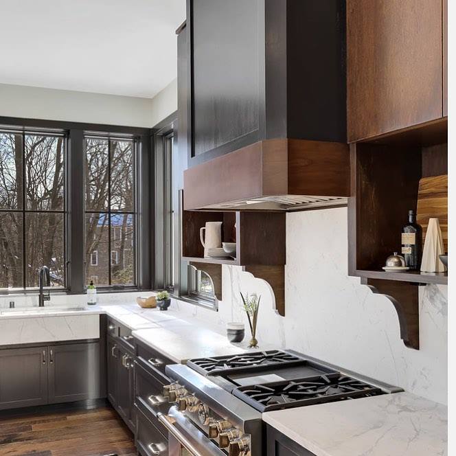 white kitchen walls are contrasted by black windows over the sink and wood cabinets over the stove