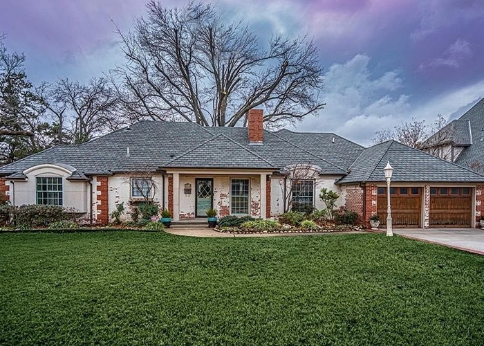 An Oklahoma single-story home exterior with white brick and traditional windows and doors