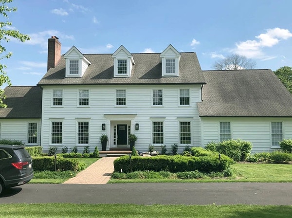 Curbside view of a New Hope colonial style home in need of modernization.