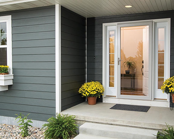 a white storm door on a front door with full light sidelights