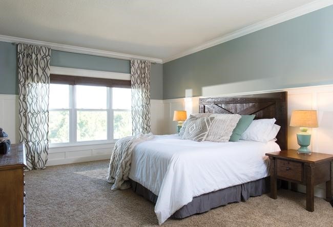 A spacious master bedroom with three white vinyl double-hung windows.