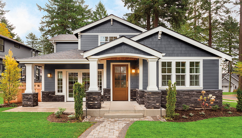 gray home with white-trimmed windows and a fiberglass wood-stained front entry door.