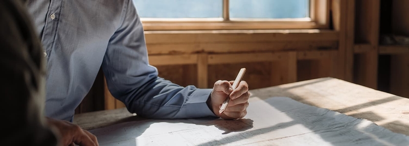 man working on a drafting table with architectural plans