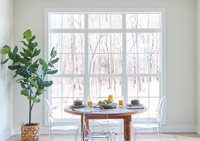 wood small table in front of a 3-wide configuration of vinyl double-hung windows