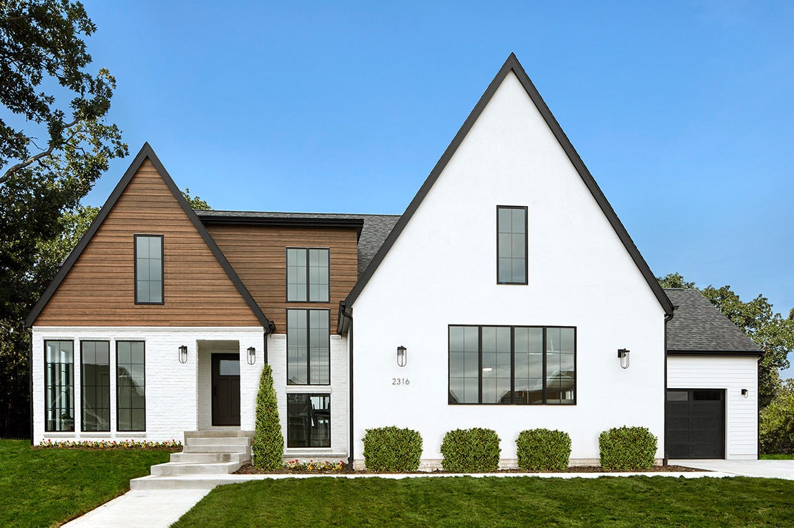 A modern home with white & wood exterior featuring traditional grille windows.