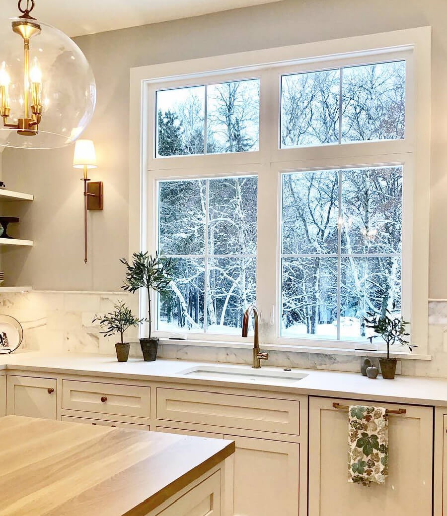 Bright white kitchen illuminated by two casement windows over the sink