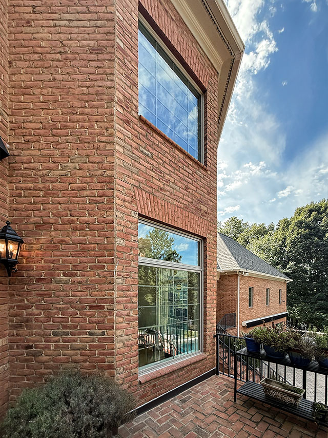 Tan Window Replacement with large windows on a brick exterior overlooking a patio.
