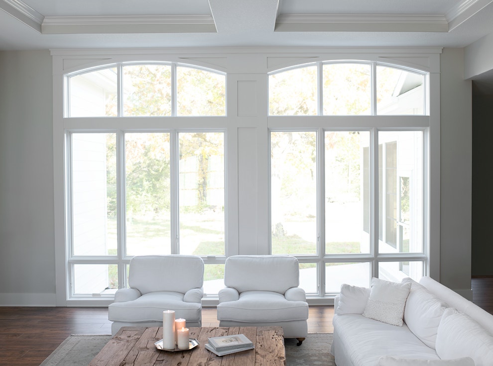 White living room with tall floor to ceiling special shape windows