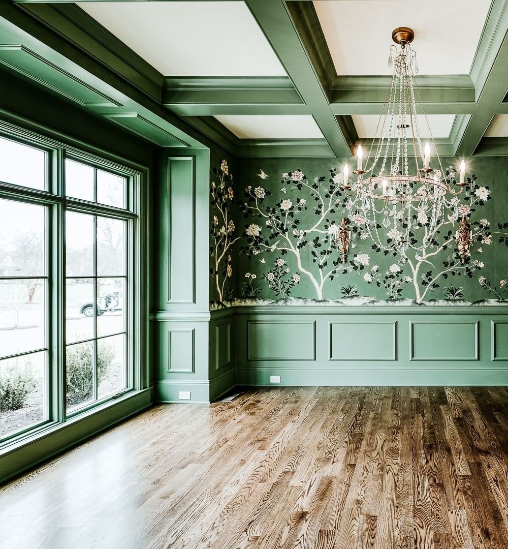 An emerald green dining room features custom wood windows painted green to match the walls.