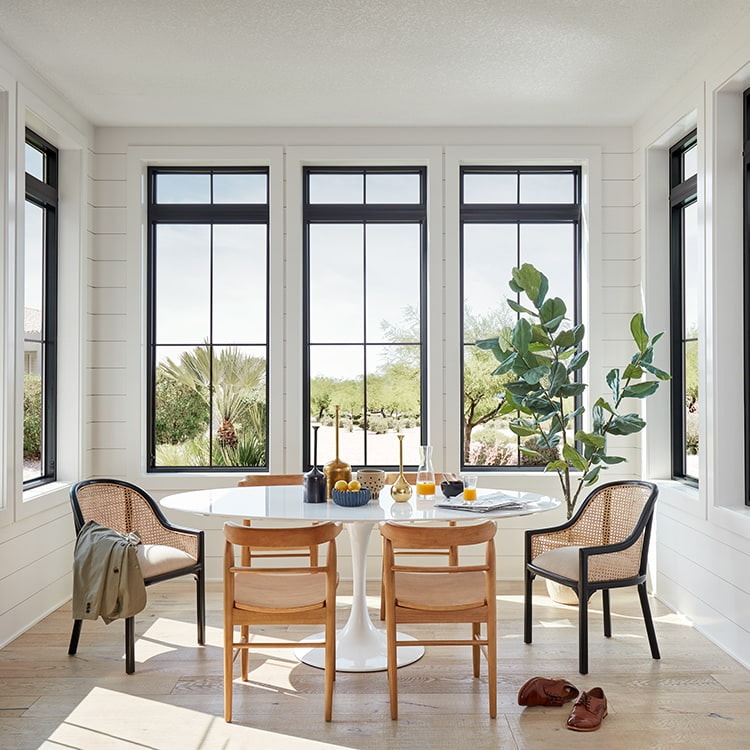 Seven black fiberglass casement windows with grilles and transoms over each.