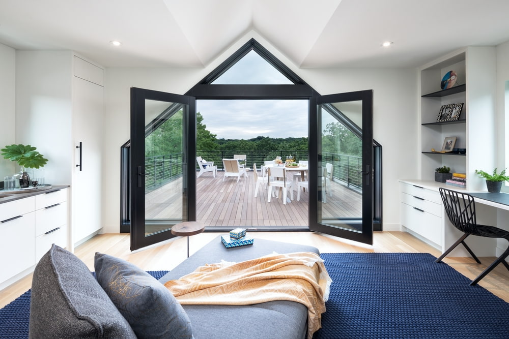 Custom Shape Windows Create Dramatic Doorway black french doors paired with special shape windows create triangle entryway to backyard patio