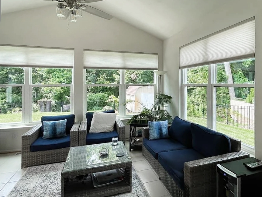 Sunroom of colonial style home in Suffolk with hidden screens for windows.