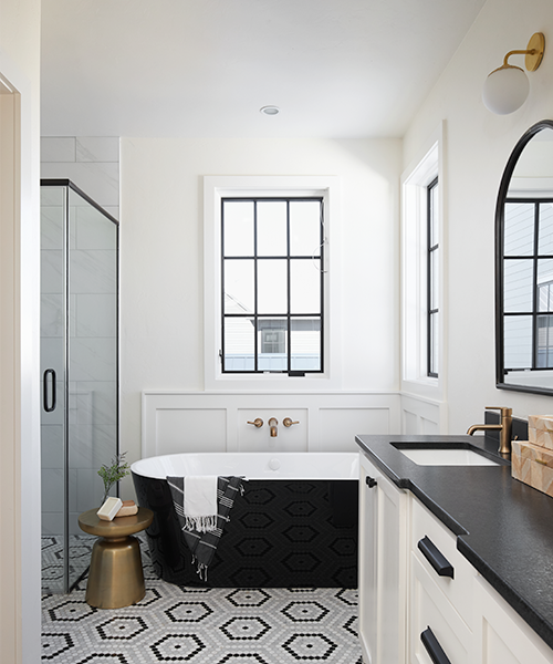 a black casement window sits over a black soaker tub in a contemporary bathroom