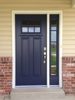 Navy blue craftsman style front door with attached sidelight on the right hand side