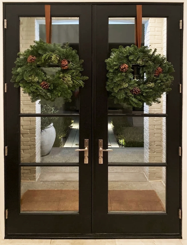 Image of a newly installed modern black french doors with wreaths on Prospect home.