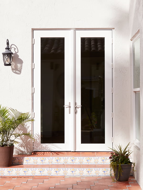 White double hinged patio door with red tiled steps and silver handles