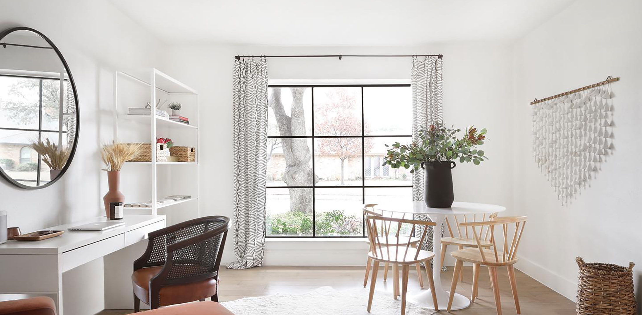 A modern and contemporary living room features a black square picture window that occupies an entire wall.