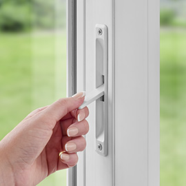Hand engaging the secondary lock on a sliding patio door.