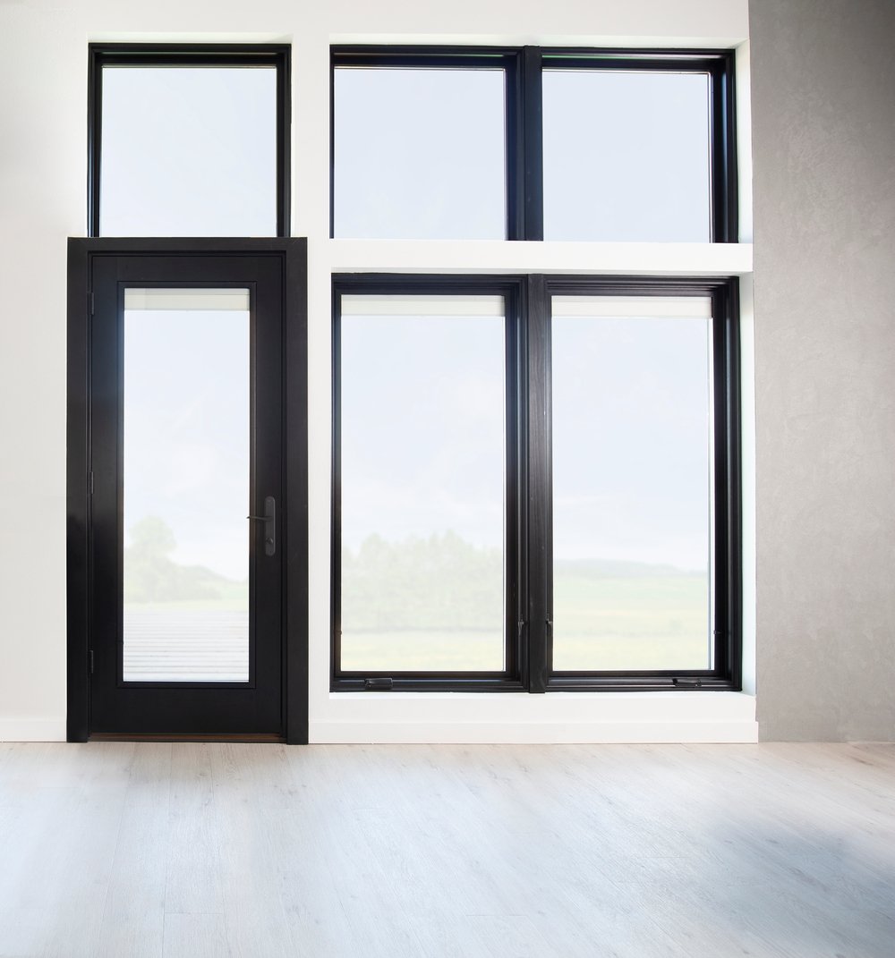 black windows surround black hinged patio door taking entire wall in modern living room