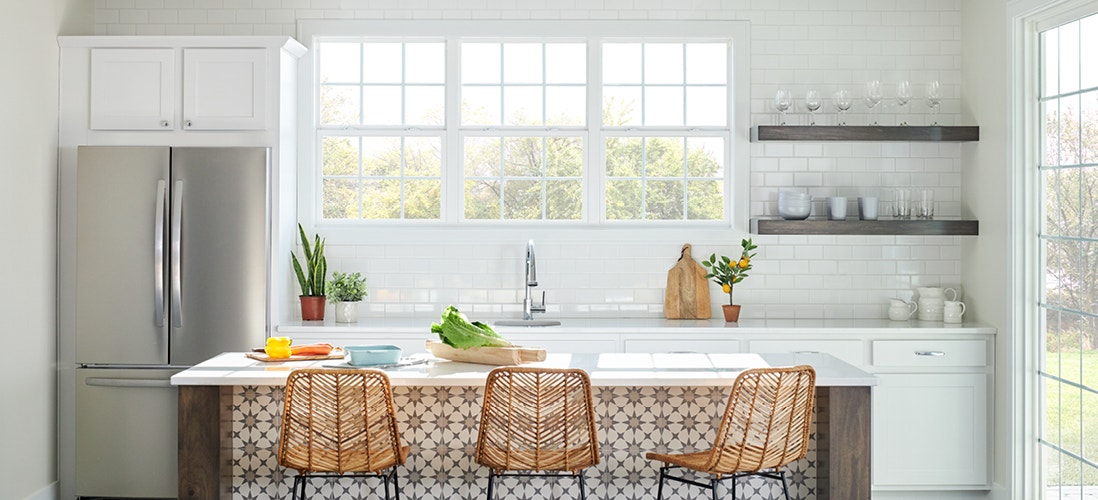 three single-hung windows in a white kitchen with orange barstools