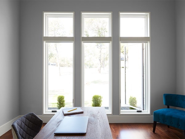 three casement windows with fixed overhead and small plants on each window sill