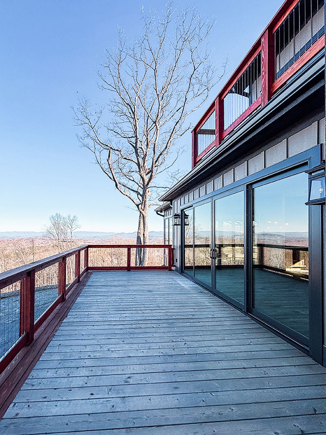 Wood deck with sliding glass doors and mountain views.